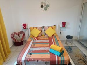 1 dormitorio con 1 cama con una manta colorida en Entre Mer et Montagne, appartement climatisé, vue mer, WIFI en Sainte-Marie