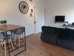 a living room with a black couch and a table at Cosy T2 31m2 - Centre-Ville Dijon - Gare et Darcy in Dijon