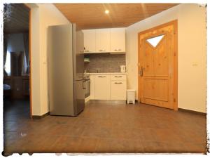 une cuisine vide avec un réfrigérateur et une porte dans l'établissement Casa Mirada, à Trin