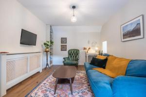 sala de estar con sofá azul y mesa en King Street Cottage in the centre of Inverness, en Inverness