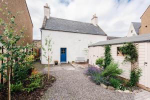 Casa blanca con puerta azul y patio en King Street Cottage in the centre of Inverness, en Inverness