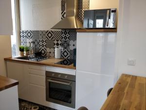 a kitchen with a stove top oven next to a counter at Cosy T2 31m2 - Centre-Ville Dijon - Gare et Darcy in Dijon