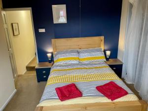 uma cama com duas almofadas vermelhas em cima em Lovely 3BD Home in the Heart of Morton em Morton