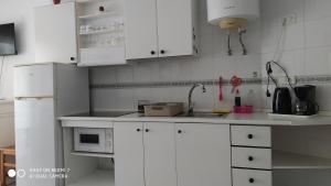 a white kitchen with white cabinets and a sink at Studio Almudena in Torrevieja