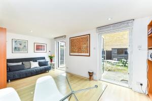 a living room with a couch and a window at Modern 4 bedroom Terraced House by the Thames in London