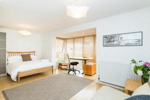 a bedroom with a bed and a desk at Modern 4 bedroom Terraced House by the Thames in London