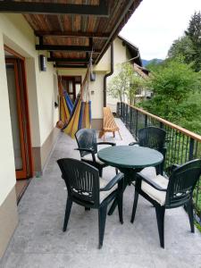 een patio met een tafel en stoelen en een hangmat bij Siesta apartment Bled in Bled