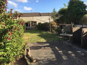 a patio with a table and chairs in a yard at Wonderfully Cosy 3BD Home in the Heart of Cornwall in St Austell
