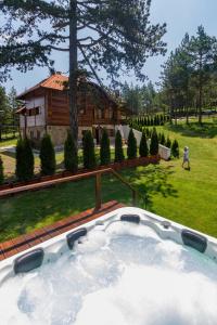 Mountain Villa Udovicic في زلاتيبور: حوض استحمام ساخن في ساحة مع منزل