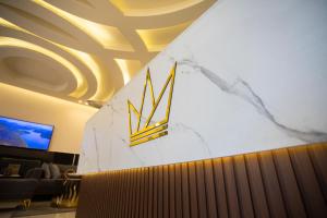 un vestíbulo con una pared de mármol con un logotipo en TAJ Hotel, en Áqaba