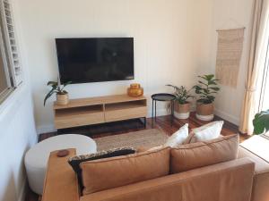 a living room with a couch and a flat screen tv at Saltwater Apartments in Lake Cathie
