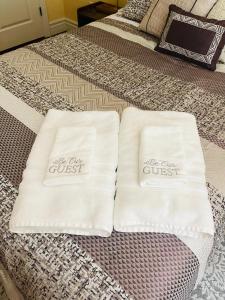 twee witte handdoeken bovenop een bed bij Private Master suite with Sauna and Bathtub in Fair Oaks