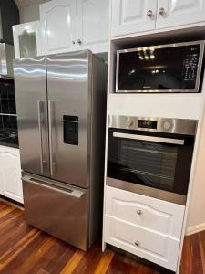 La cuisine est équipée d'un réfrigérateur en acier inoxydable et d'un four micro-ondes. dans l'établissement Affordable getaways, à Caroline Springs