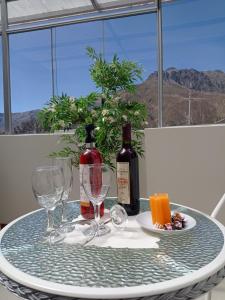 a table with two glasses and a bottle of wine at Colca Canyon Hotel in Chivay