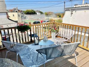 a patio with two chairs and a table on a deck at The Terrace - Tankerton in Kent