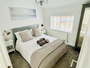 a bedroom with a white bed with a dog on it at The Terrace - Tankerton in Kent