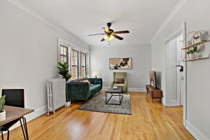 uma sala de estar com um sofá verde e uma ventoinha de tecto em Deluxe 1BR Apartment in Ravenswood - Campbell 3 em Chicago