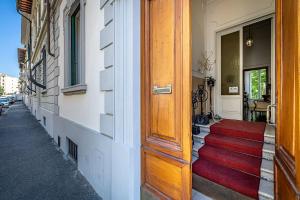 een deur naar een gebouw met een rood tapijt op de trap bij A Casa di Lilli in Florence