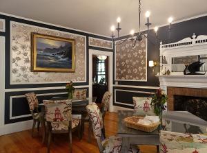 a dining room with a table and chairs and a fireplace at Sand Bar Cottage Inn in Bar Harbor