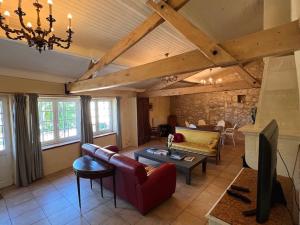 a living room with a couch and a table at La Maison Pourpre in Vélines