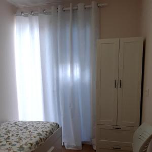 a bedroom with a bed and a white curtain at LOFT FRIOL in Friol +5 photos