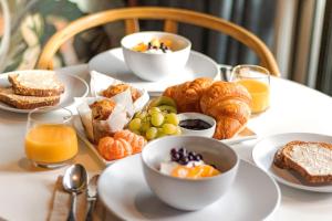 a table with plates of breakfast foods and orange juice at Matamata Lodge in Matamata