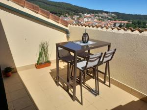 - Balcón con mesa pequeña y 2 sillas en Margaritas, en Finisterre