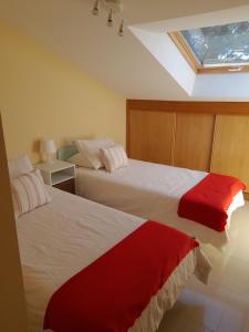 フィステーラにあるMargaritasのベッドルーム1室(ベッド2台、赤と白のシーツ付)