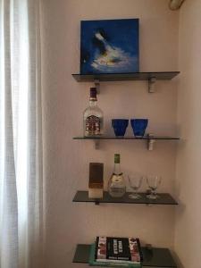 een plank met flessen en glazen aan de muur bij Cozy Apartment near Ohrid Lake in Pogradec