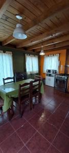 cocina con mesa verde y sillas en una habitación en Concolor en El Chaltén