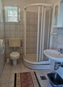 a bathroom with a shower and a toilet and a sink at Apartments by the sea Zivogosce - Mala Duba, Makarska - 18626 in Igrane