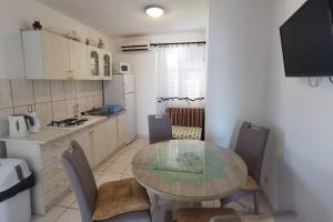 a kitchen with a table and chairs in a kitchen at Apartments by the sea Zivogosce - Mala Duba, Makarska - 18626 in Igrane