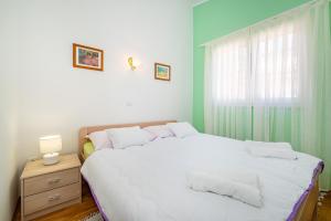 ein Schlafzimmer mit einem großen weißen Bett und einem Fenster in der Unterkunft Apartments by the sea Privlaka, Zadar - 18652 in Privlaka