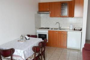 a kitchen with a table and a sink and a stove at Apartments by the sea Loviste, Peljesac - 18656 in Lovište