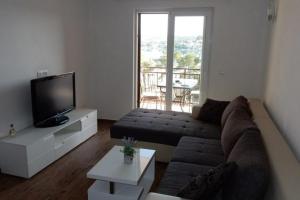 a living room with a couch and a flat screen tv at Apartments by the sea Loviste, Peljesac - 18656 in Lovište
