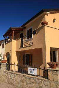 una casa grande con un cartel en una valla en Apartments with a parking space Punta kriza, Cres - 18644, en Nerezine