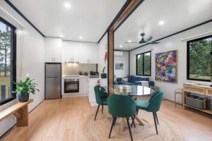 a kitchen and dining room with a table and chairs at Contained in Nimbin Accommodation in Nimbin