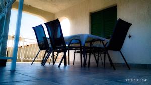 a table and chairs on a balcony with a green door at Apartments by the sea Necujam, Solta - 18664 in Grohote +13 photos