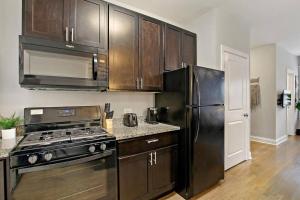 Il comprend une cuisine équipée d'une cuisinière et d'un réfrigérateur. dans l'établissement Stylish Studio Apartment in Portage Park - Pensacola 2N, à Chicago