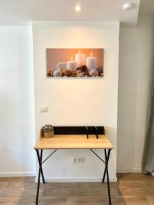 une table en bois avec des bougies sur un mur dans l'établissement Thuir, Charmante Maison T2 Climatisée, à Thuir