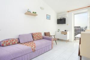 a living room with a purple couch and a table at Apartments and rooms with parking space Kastel Stafilic, Kastela - 18673 in Kaštela