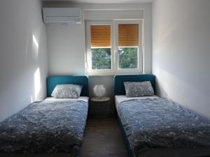 - 2 lits dans une chambre avec 2 fenêtres dans l'établissement Apartments with WiFi Opatija - Volosko, Opatija - 18675, à Opatija