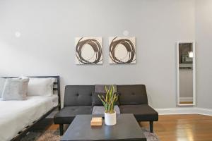 - un salon avec un canapé et une table dans l'établissement Stylish Studio Apartment in Portage Park - Pensacola 2N, à Chicago