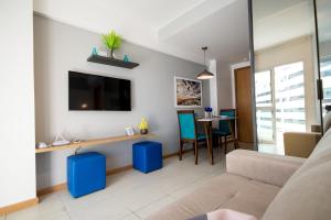 a living room with a couch and a tv at SMART Flats - Decorado Superior - 11º andar - Esplanada - Saint Moritz in Brasilia