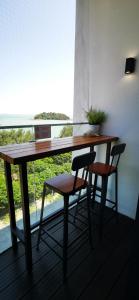 una mesa de madera con 2 sillas y una ventana en Dwharf Seaview Executive Suit PortDickson, en Port Dickson