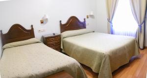 1 dormitorio con 2 camas y ventana en Hotel Chipén, en Vigo