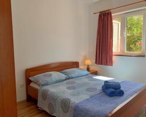 ein Schlafzimmer mit einem Bett mit einer blauen Tasche darauf in der Unterkunft Apartments by the sea Silo, Krk - 18680 in Šilo