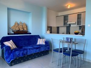 ein Wohnzimmer mit einem blauen Sofa, einem Tisch und Stühlen in der Unterkunft Apartments by the sea Silo, Krk - 18680 in Šilo