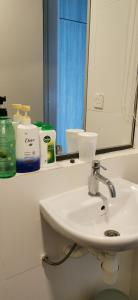 W łazience znajduje się biała umywalka i lustro. w obiekcie Dwharf Seaview Executive Suit PortDickson w mieście Port Dickson
