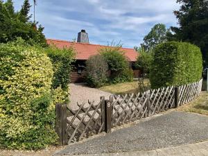 uma cerca de madeira em frente a uma casa em House, Suhlendorf em Suhlendorf